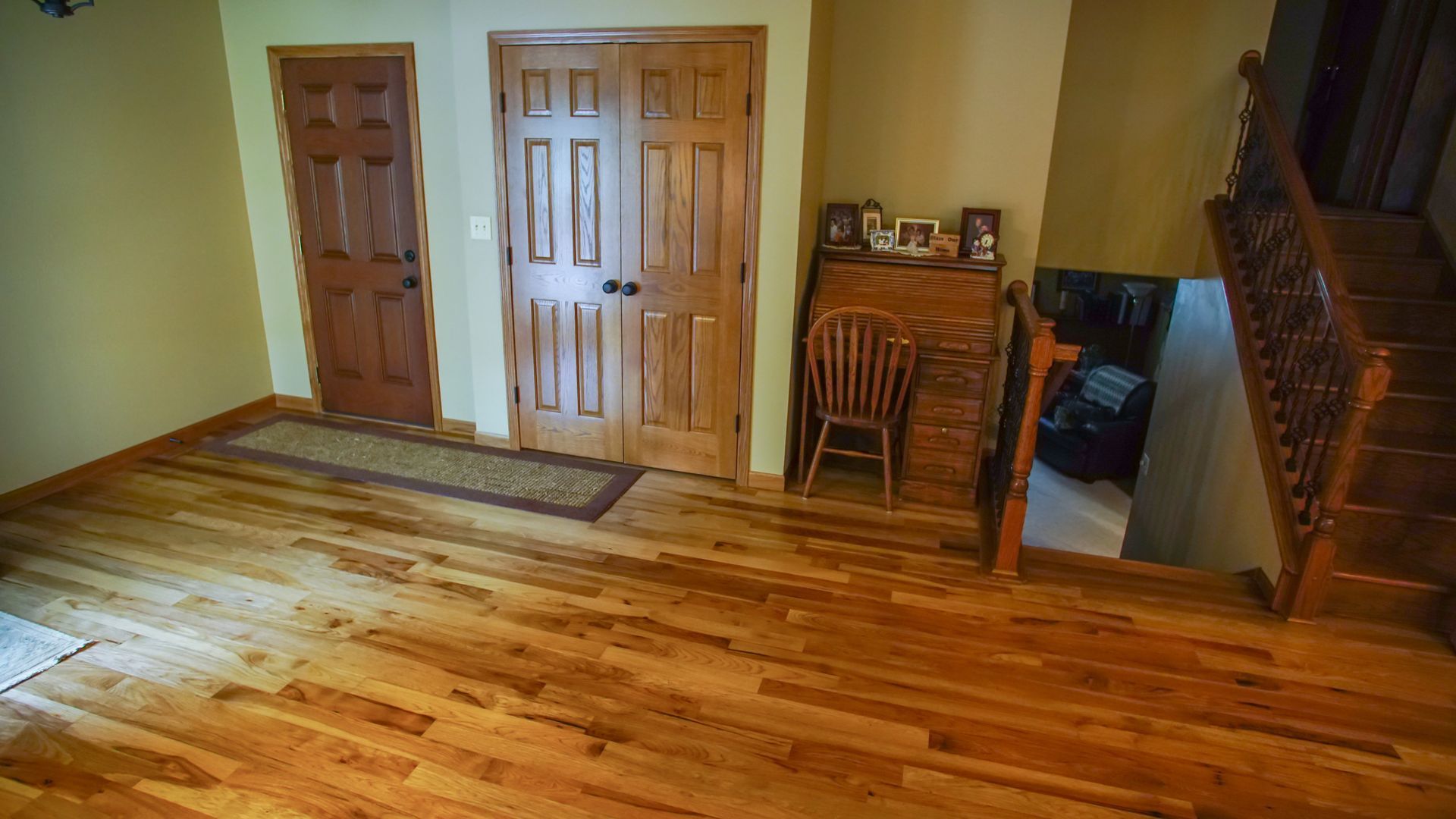 A living room with hardwood floors and stairs leading up to the second floor.