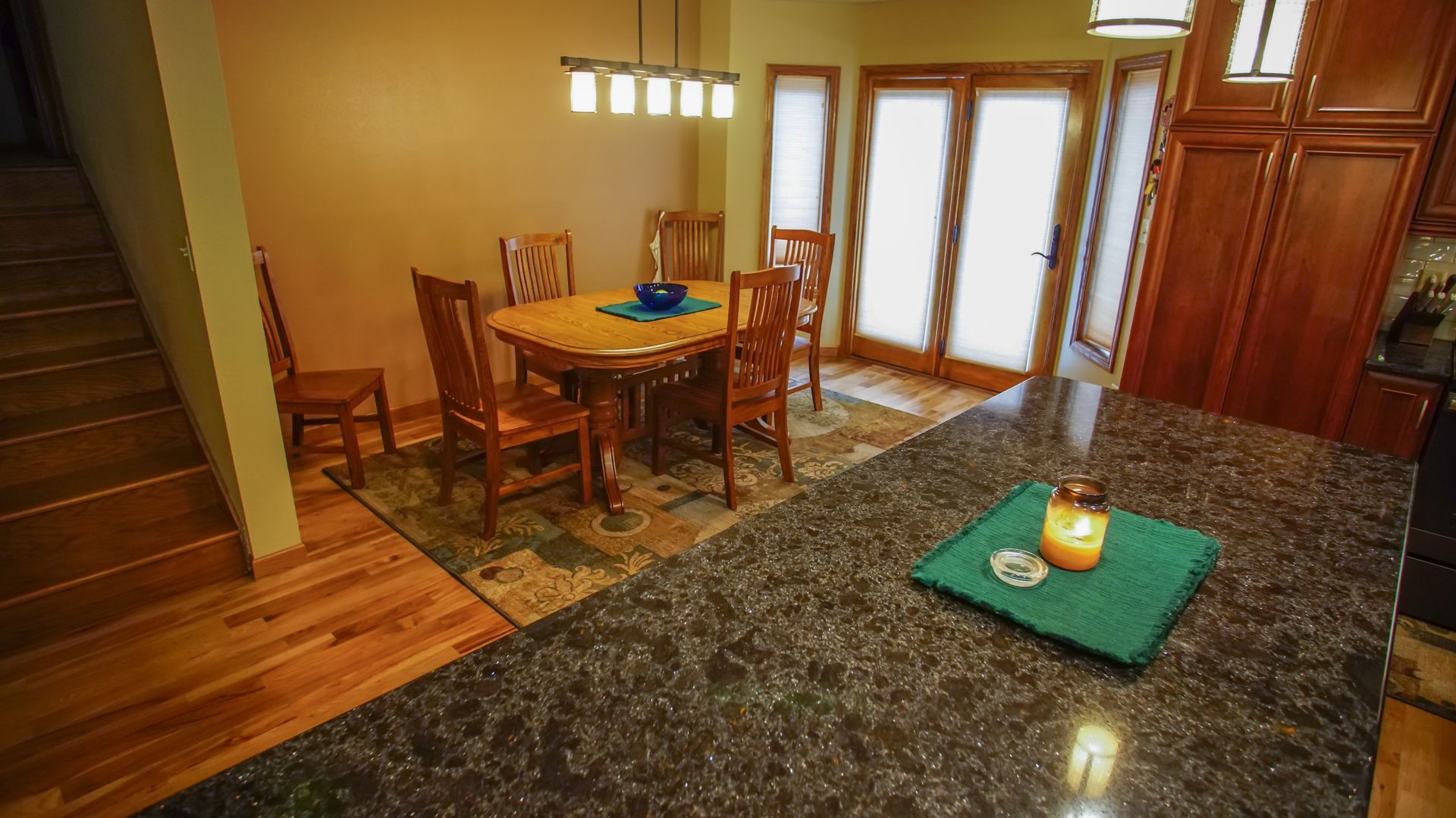 A kitchen with a table and chairs and a candle on the counter.