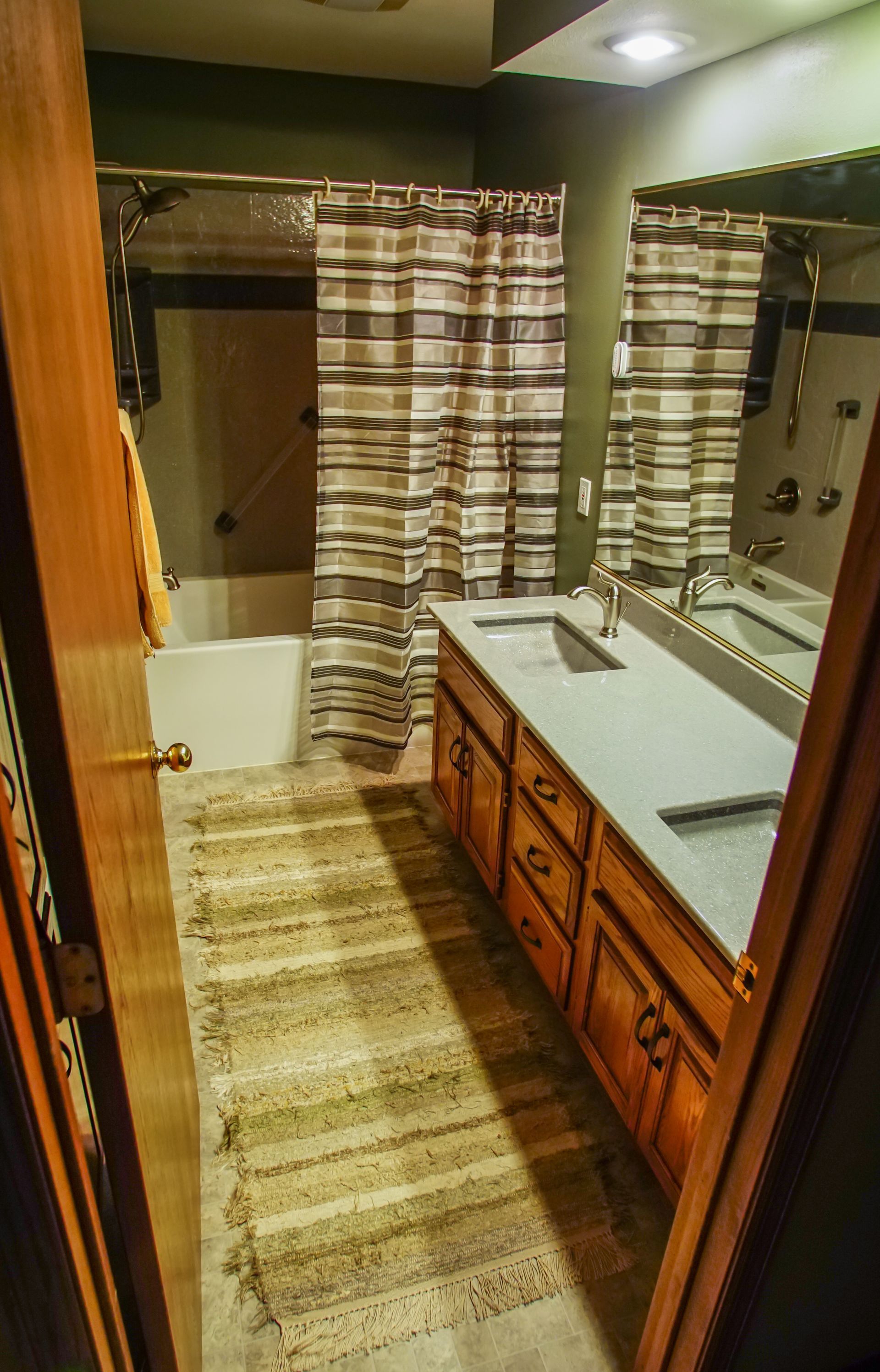 A bathroom with two sinks, a bathtub and a shower curtain.