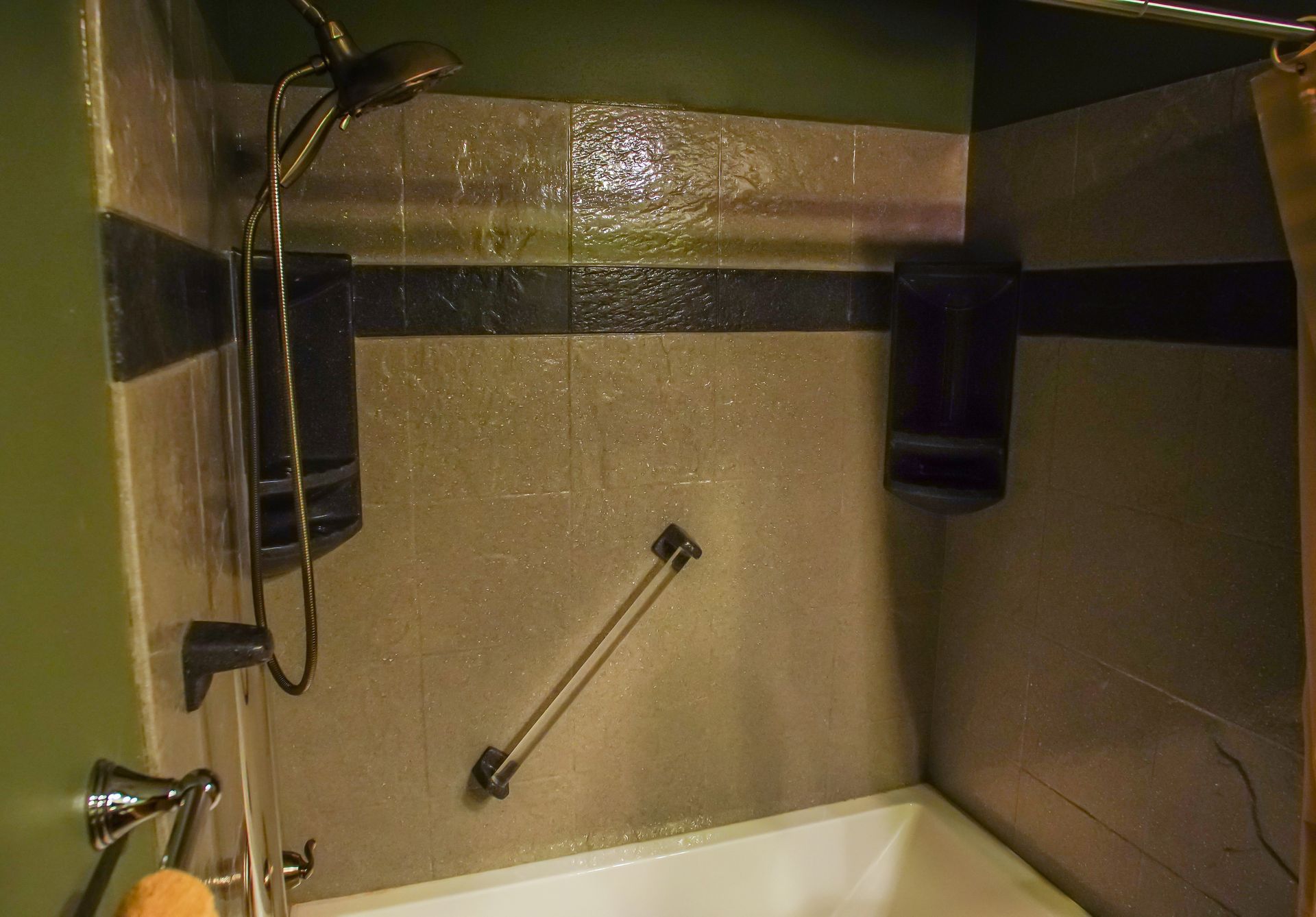 A bathroom with a bathtub and a shower head