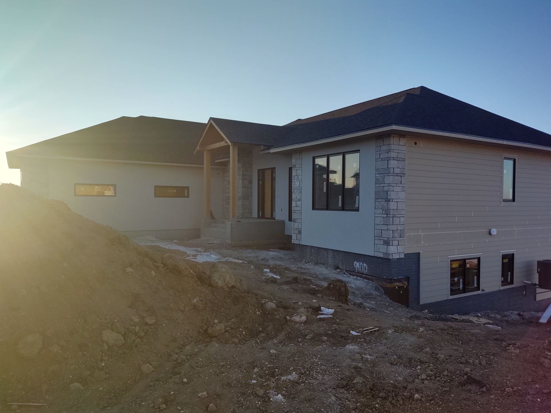 A house is being built on top of a dirt hill.