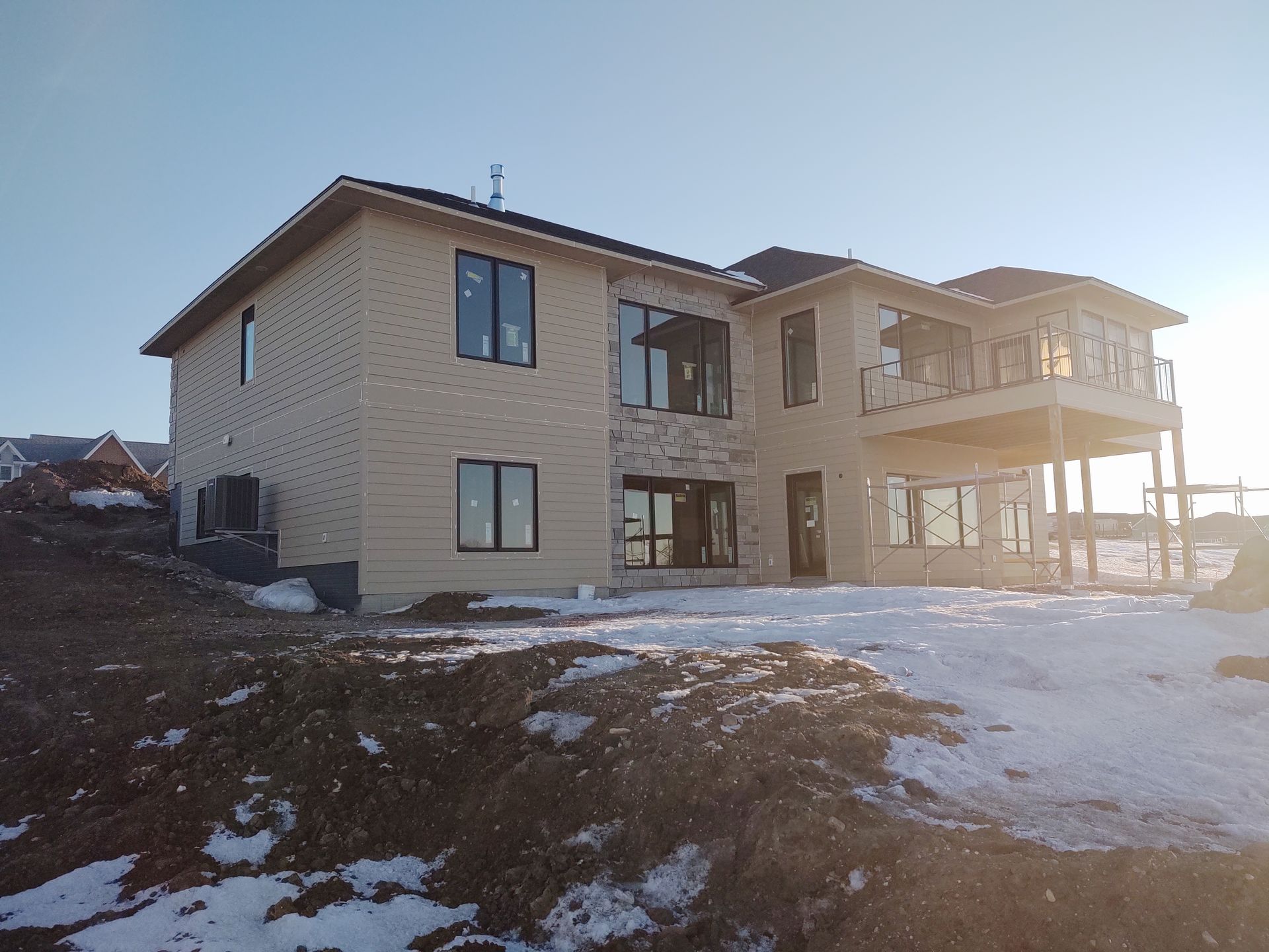 A large house is sitting on top of a snow covered hill.