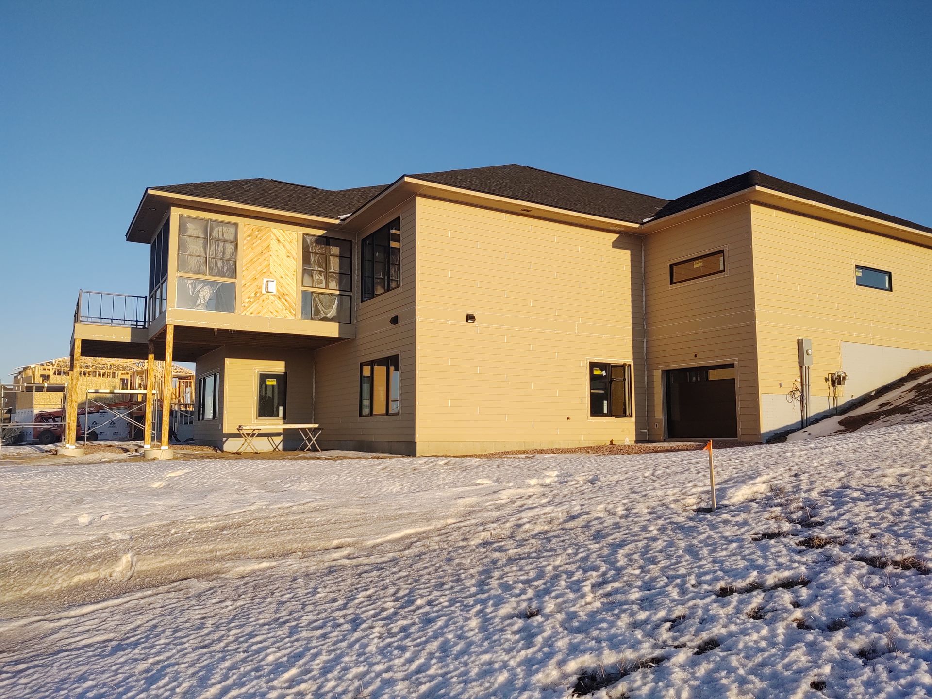 A large house is under construction in the snow