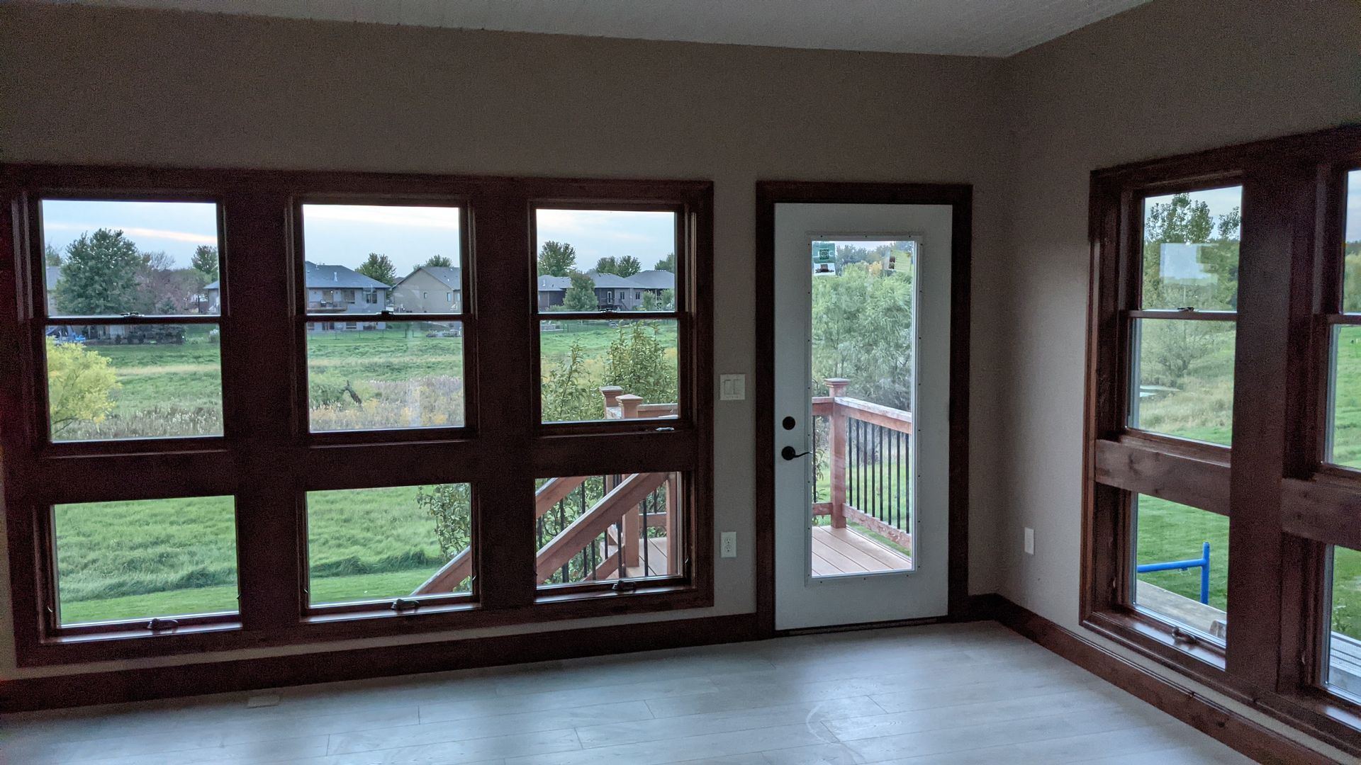 An empty room with a lot of windows and a door