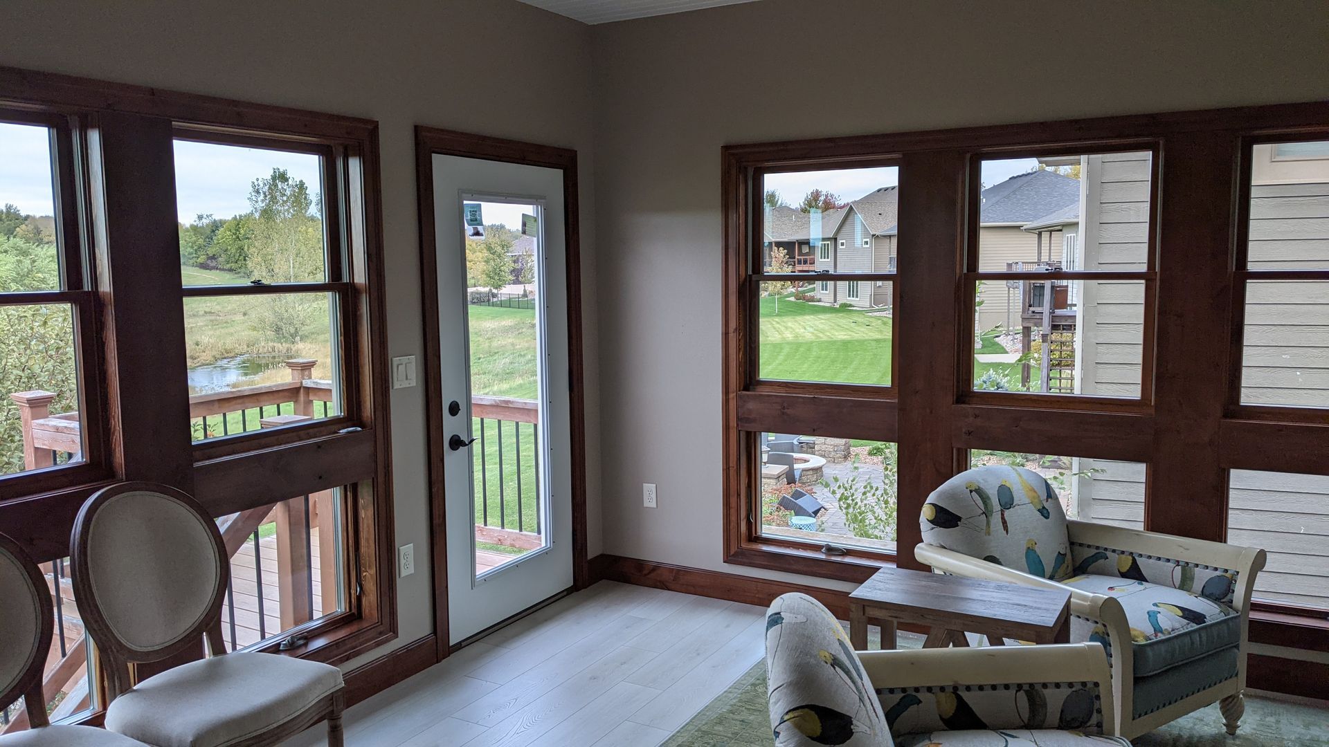 A living room with a lot of windows and chairs.