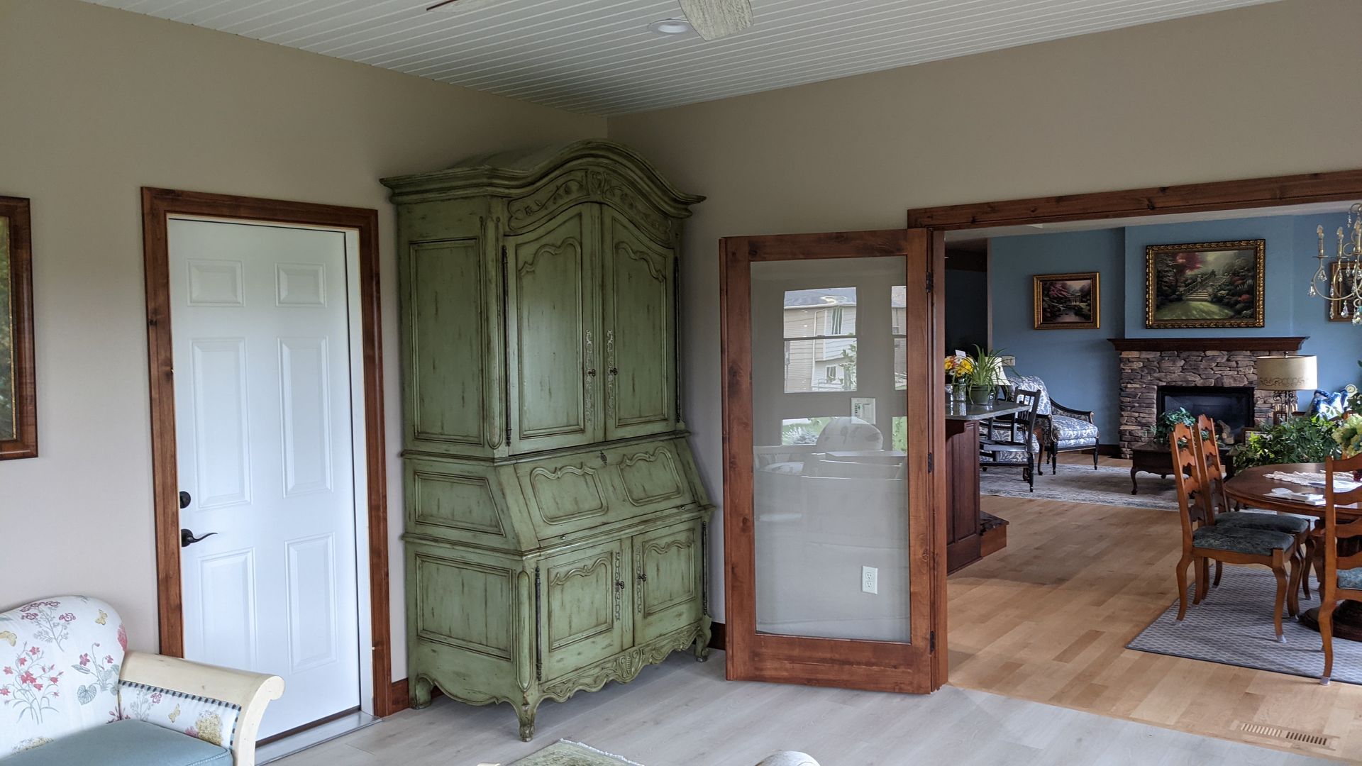 A living room with a green cabinet and a fireplace