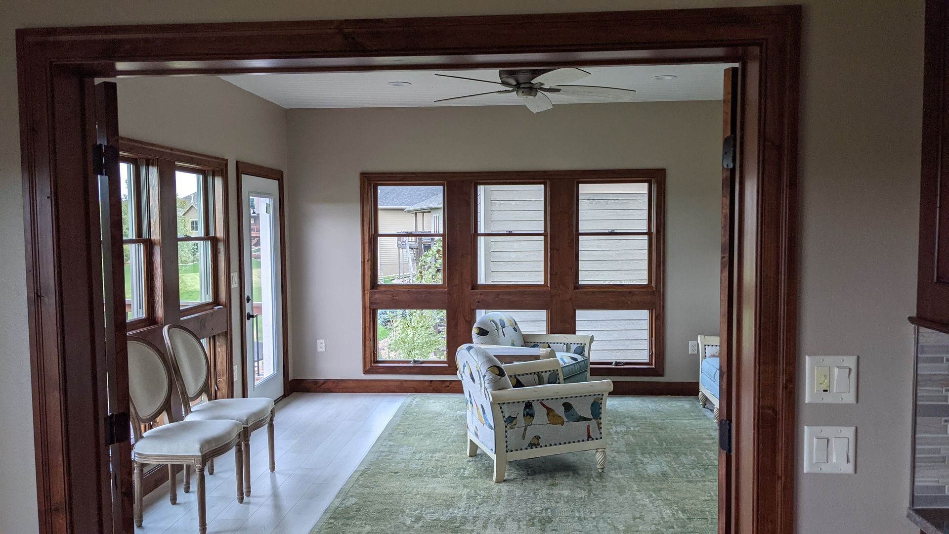 A living room with a lot of windows and chairs