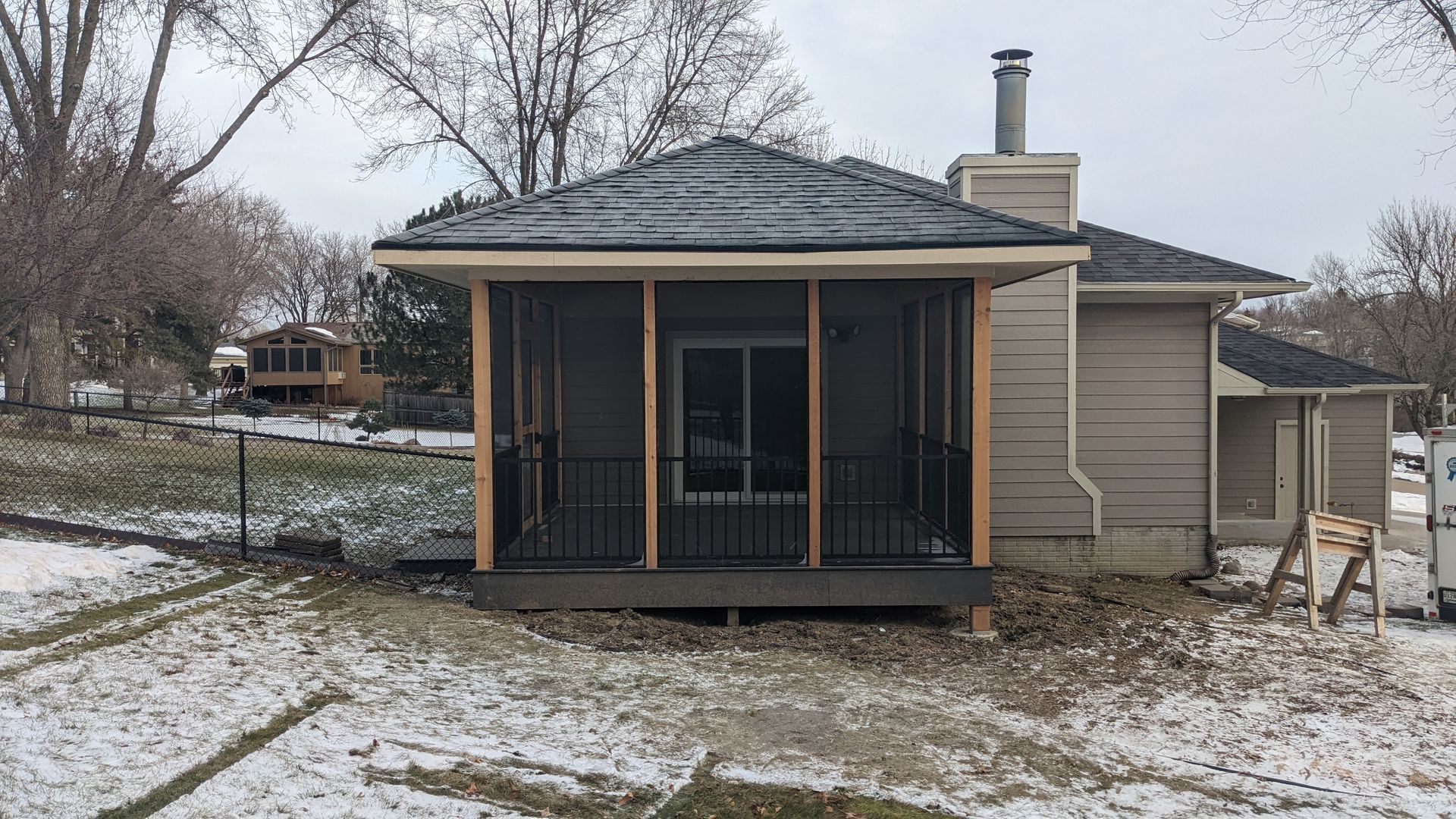 A screened in porch is being built on the side of a house.