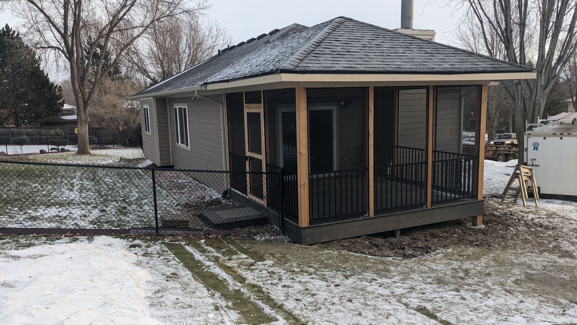 A screened in porch is being built on the side of a house.