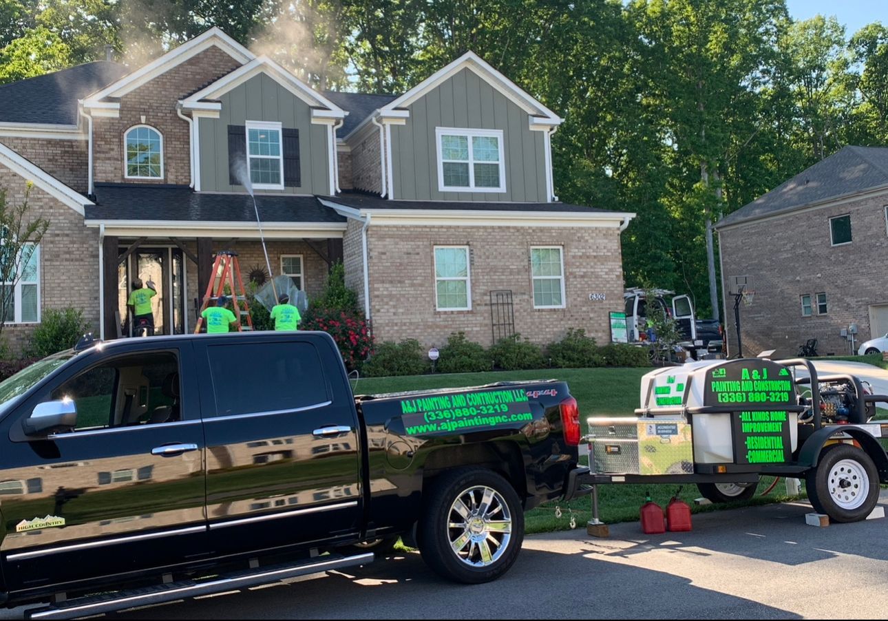 A black truck is parked in front of a large brick house