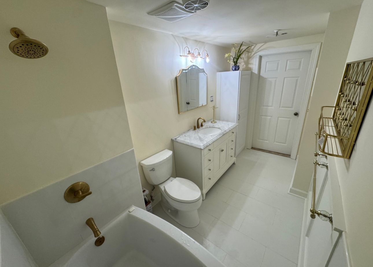 A bathroom with a toilet , sink and bathtub.
