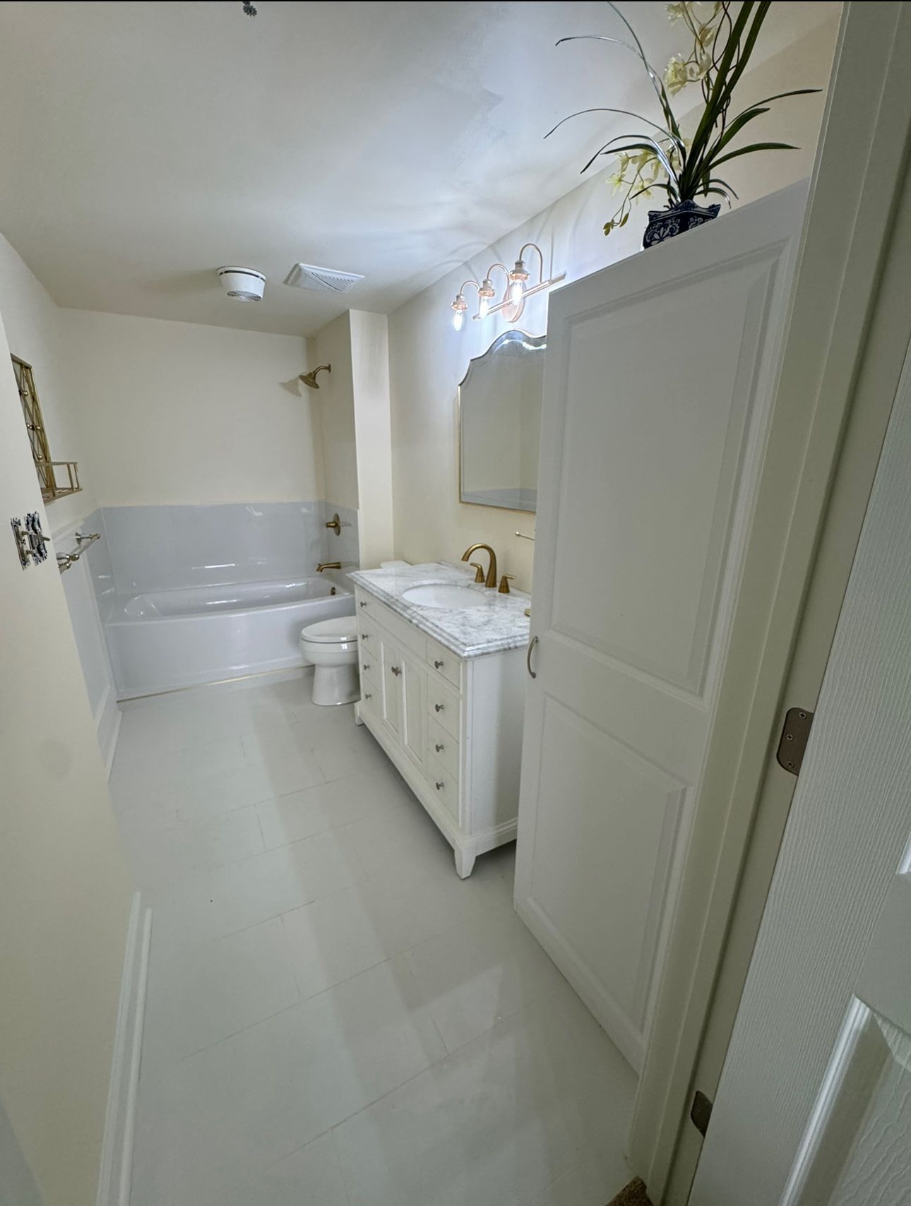 A bathroom with a tub , sink , toilet and mirror.