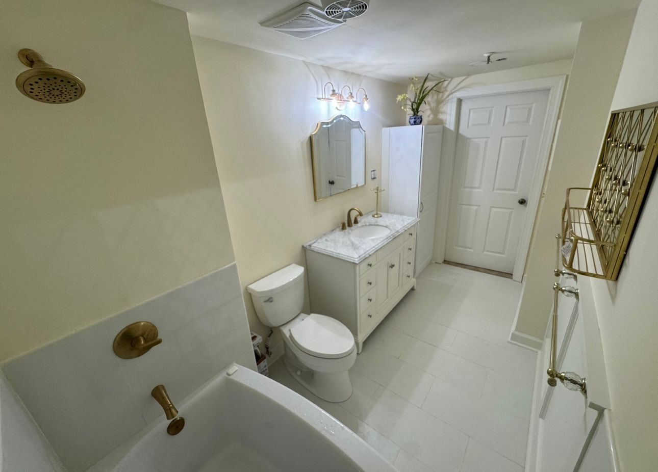 A bathroom with a toilet , sink and bathtub.
