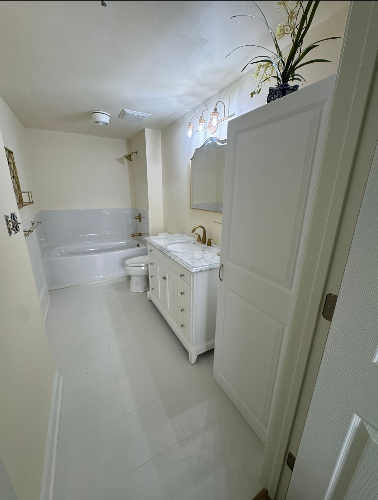 A bathroom with a tub , sink , toilet and mirror.