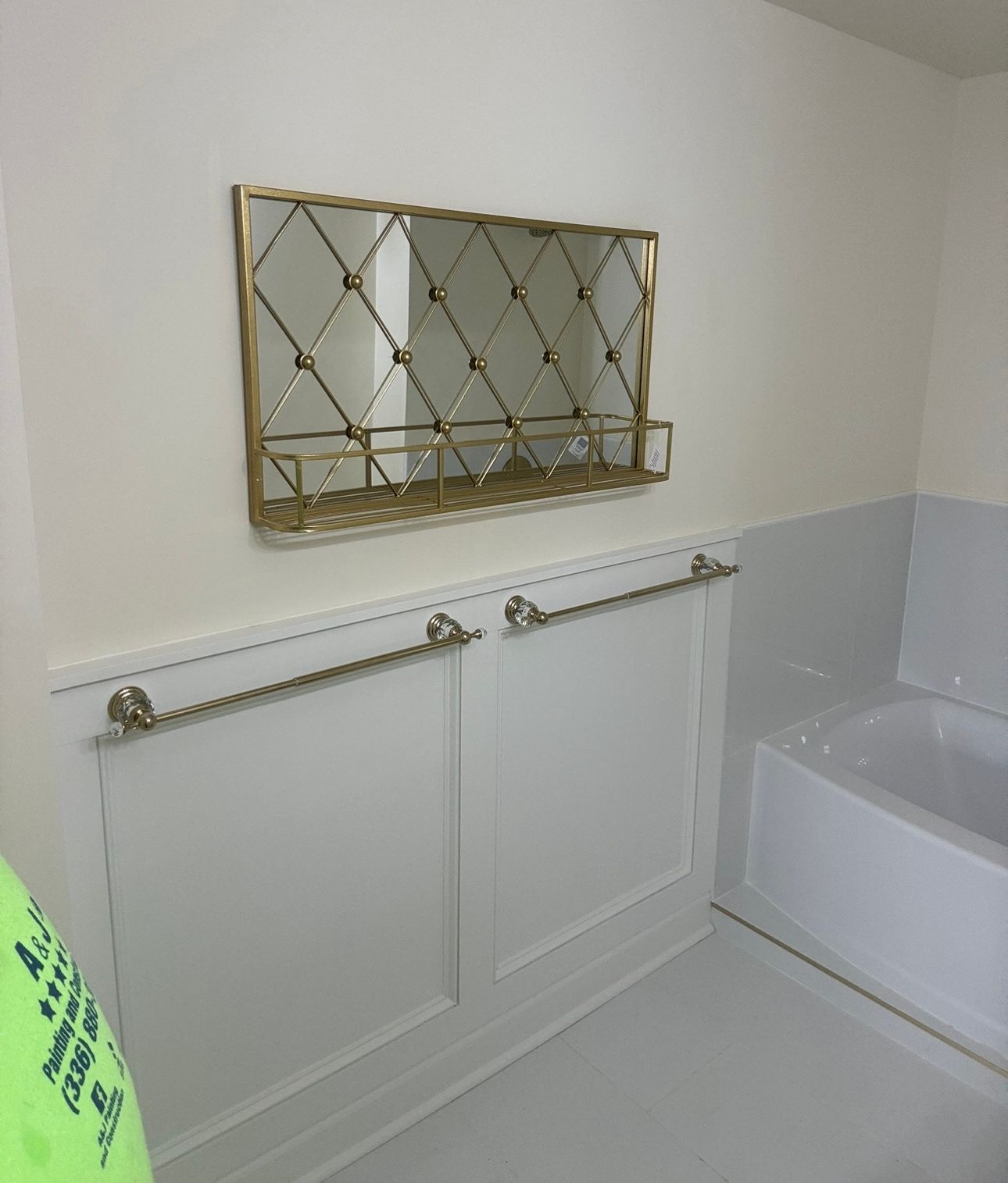 A bathroom with a bathtub and a mirror on the wall