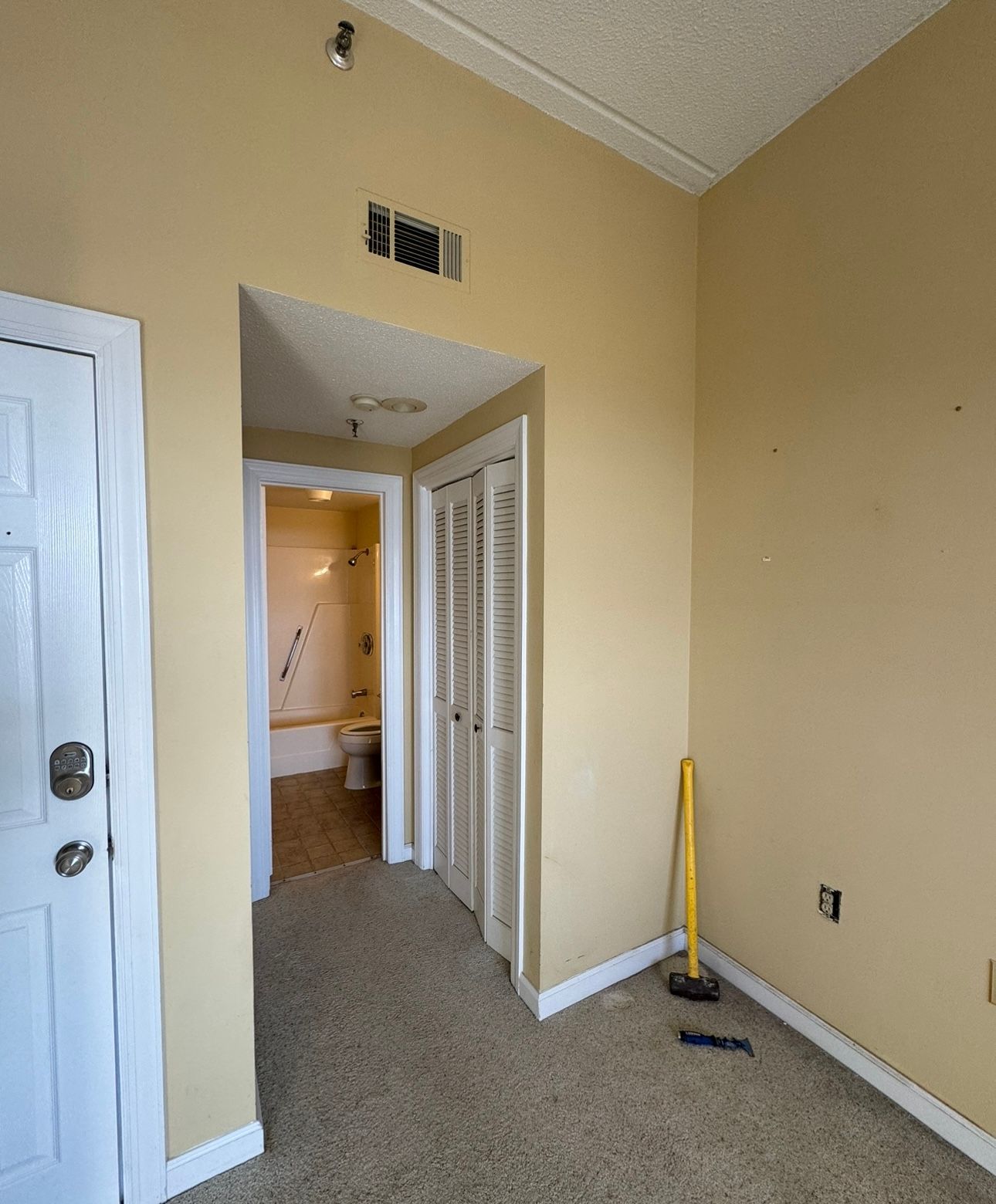 An empty room with a doorway leading to a bathroom.