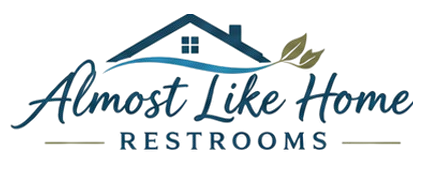 Pink floral banner reading &ldquo;Almost Like Home Restroom Trailer&rdquo; with decorative swirls and butterflies