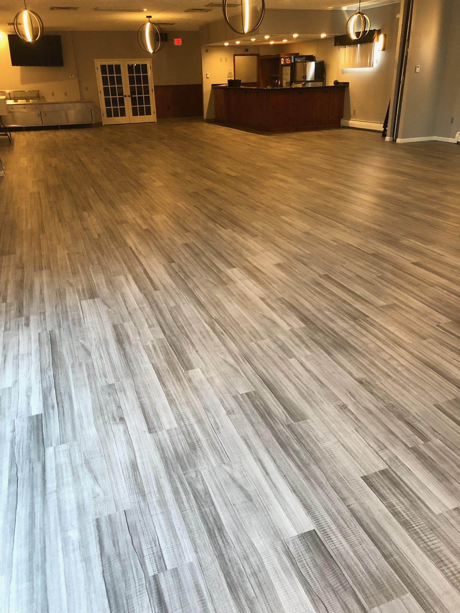 A large room with a wooden floor and a reception desk.