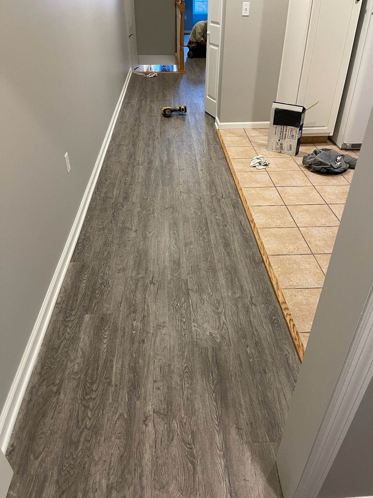 A hallway with a hardwood floor and a tile floor.