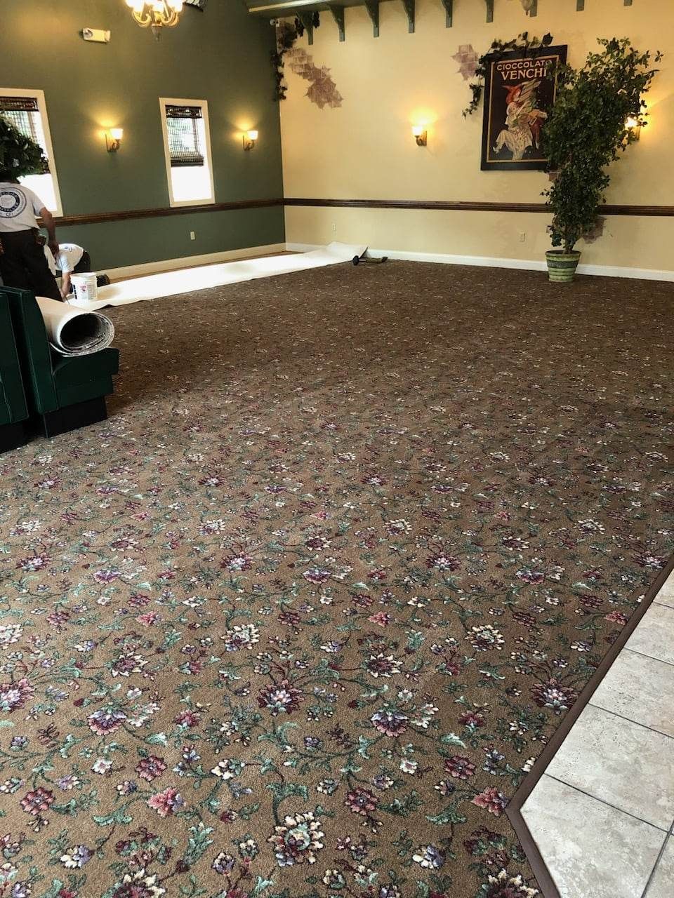 A large room with a floral carpet and a chair.