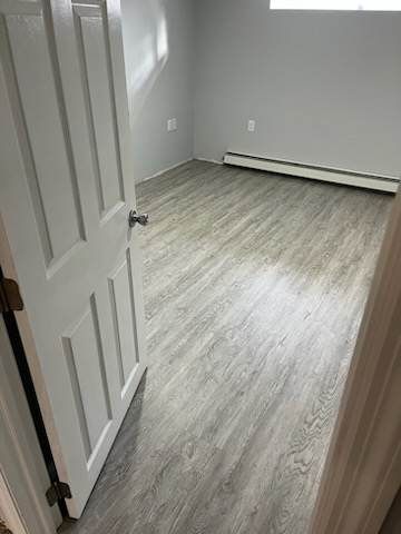 A bedroom with hardwood floors and a white door.