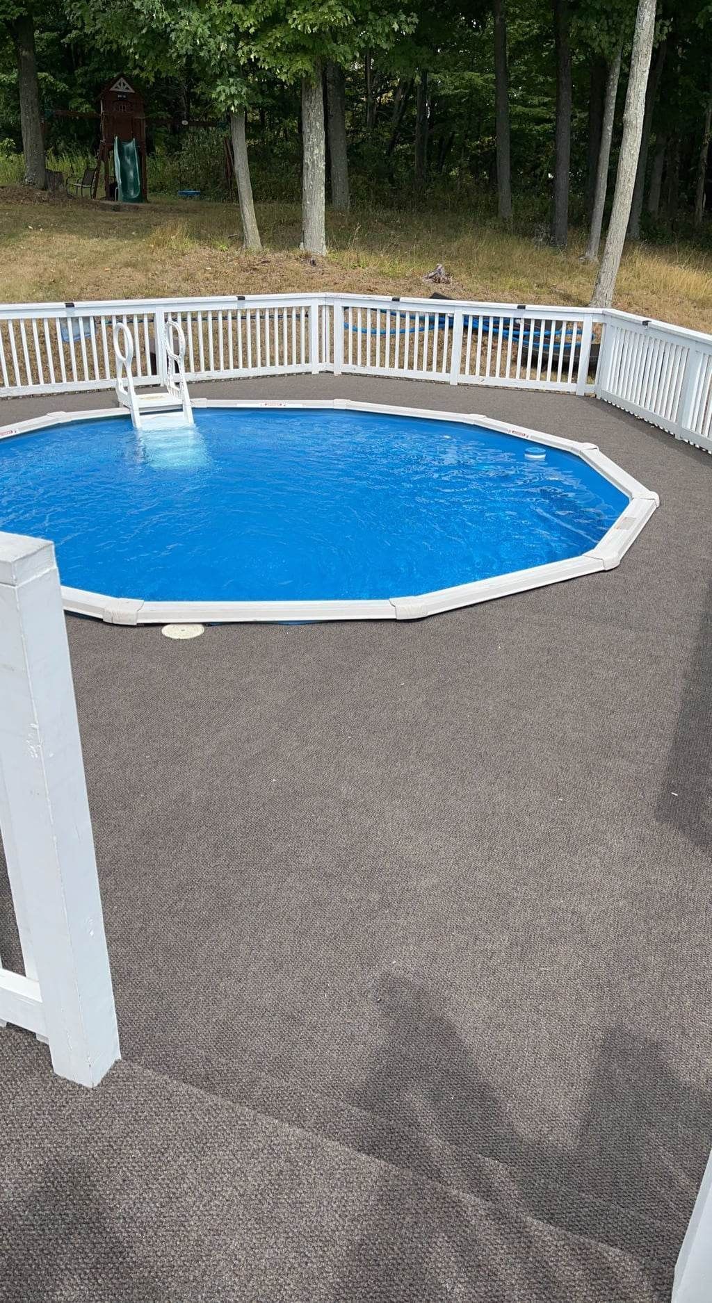 A large swimming pool with a white fence around it.