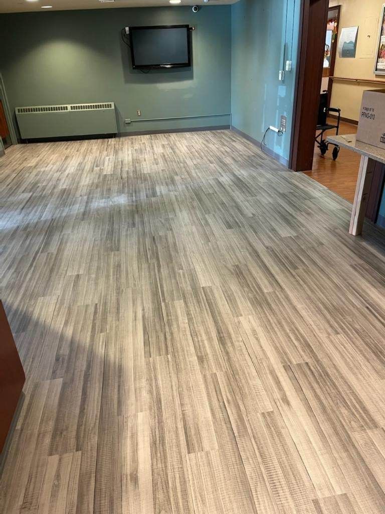 A large room with a wooden floor and a flat screen tv on the wall.