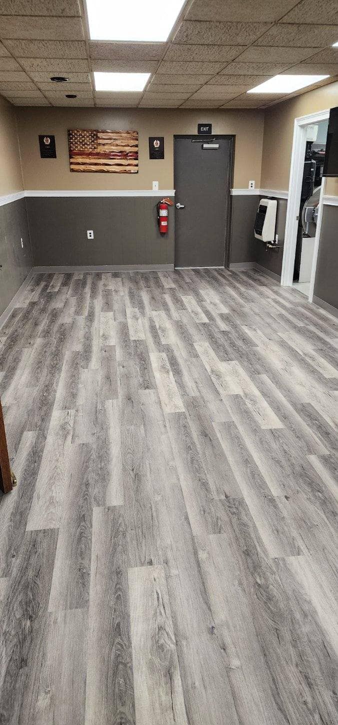 A large room with a wooden floor and a door.