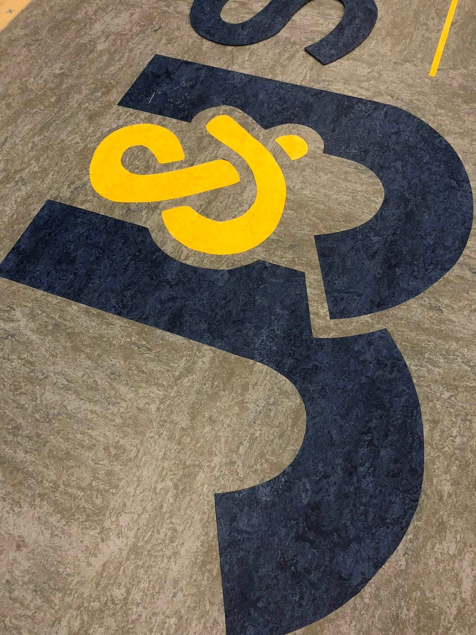A close up of a blue and yellow logo on a carpet.