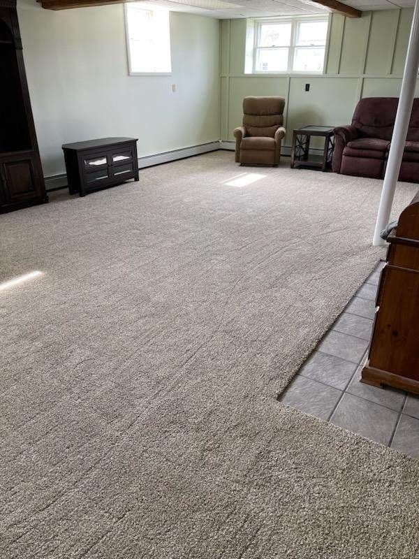 A living room with a large carpeted floor and two chairs.
