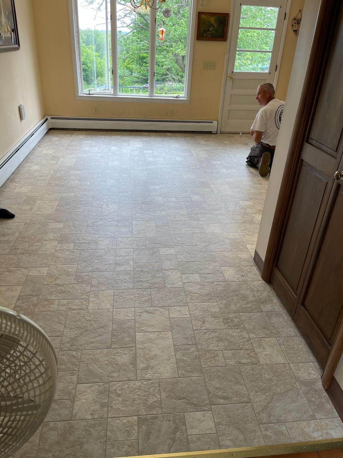 A man is kneeling on the floor in a living room.