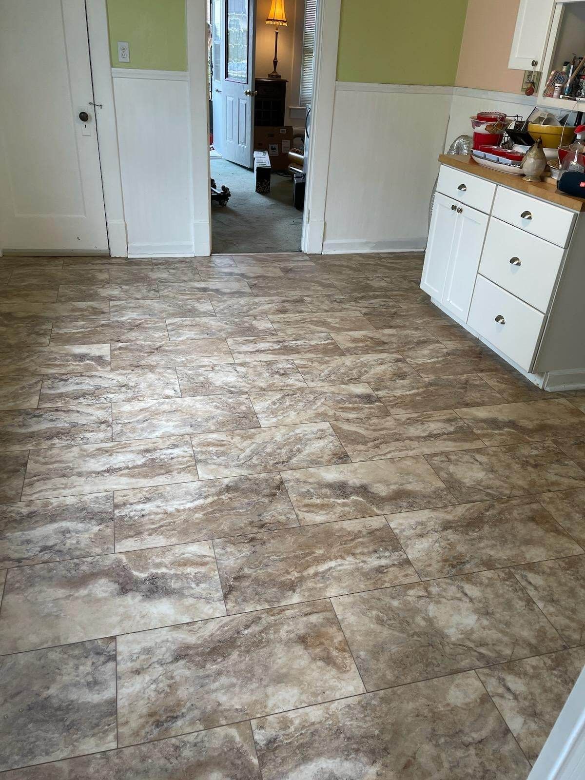 A kitchen with a wooden floor and a white cabinet.