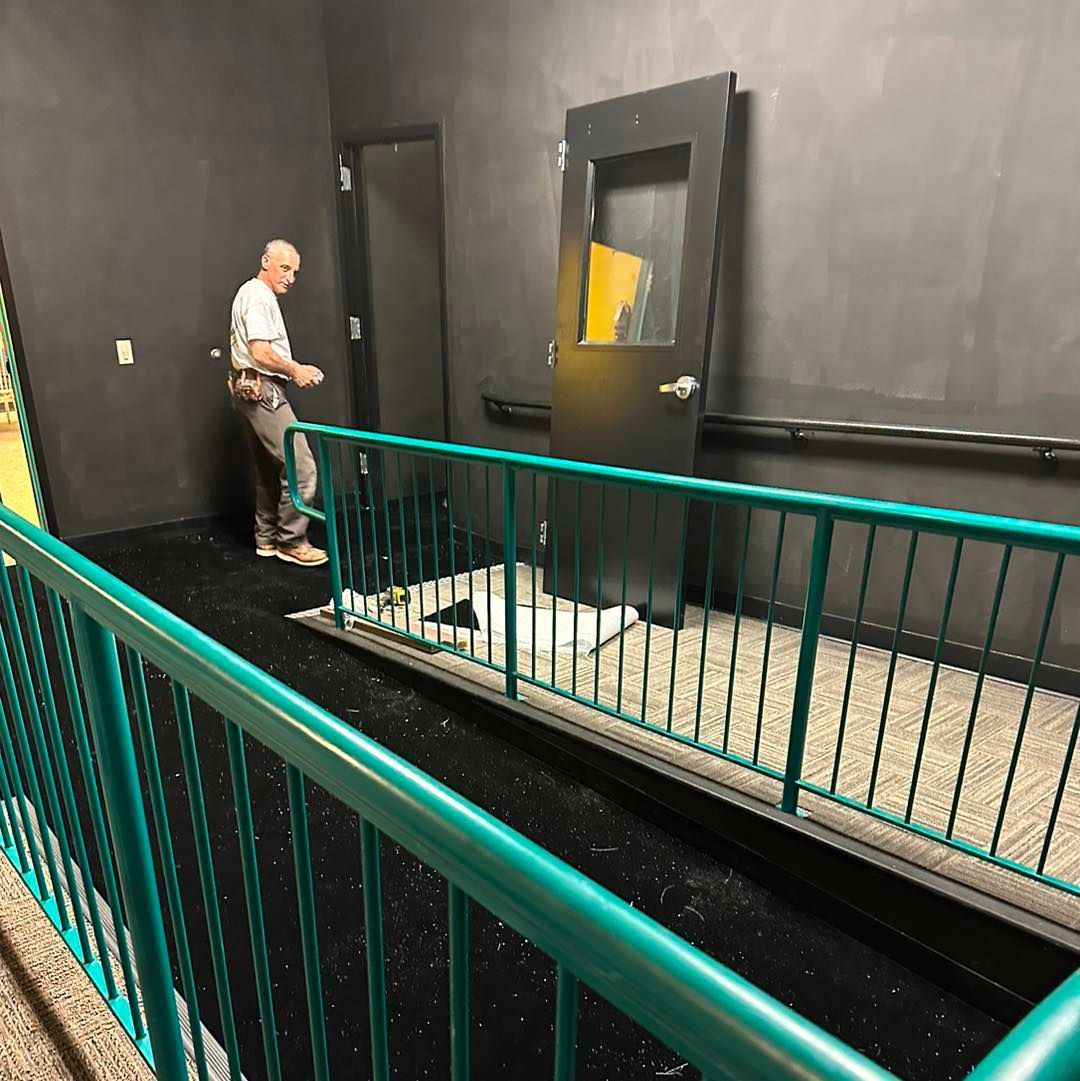 A man standing next to a green railing in a dark room
