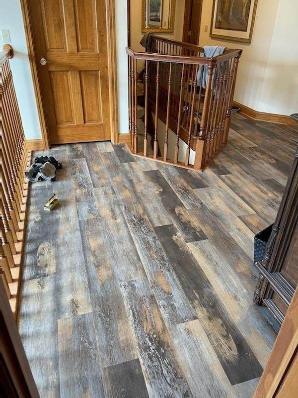 A hallway with hardwood floors and a wooden staircase.