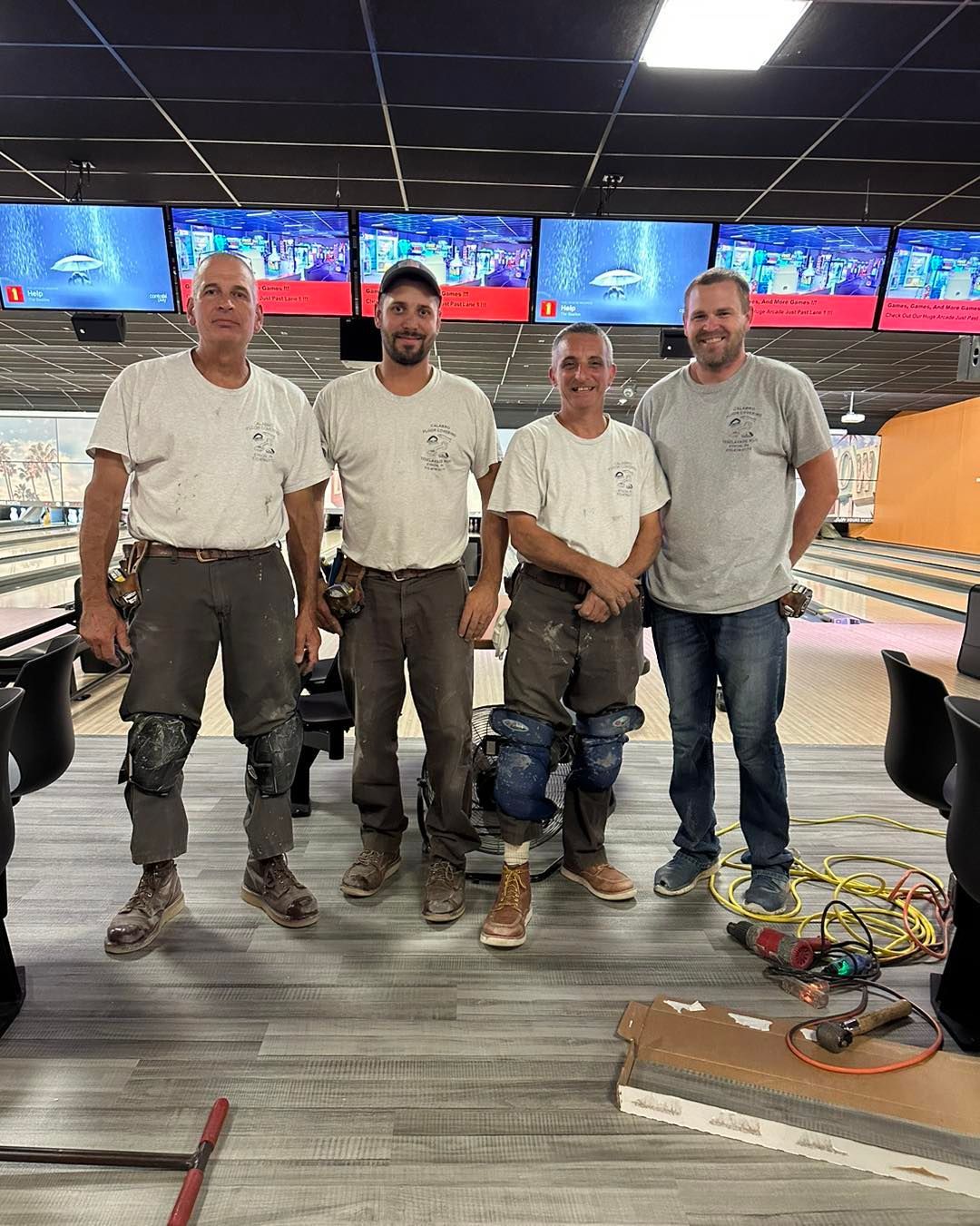 A group of men are standing next to each other in a bowling alley.