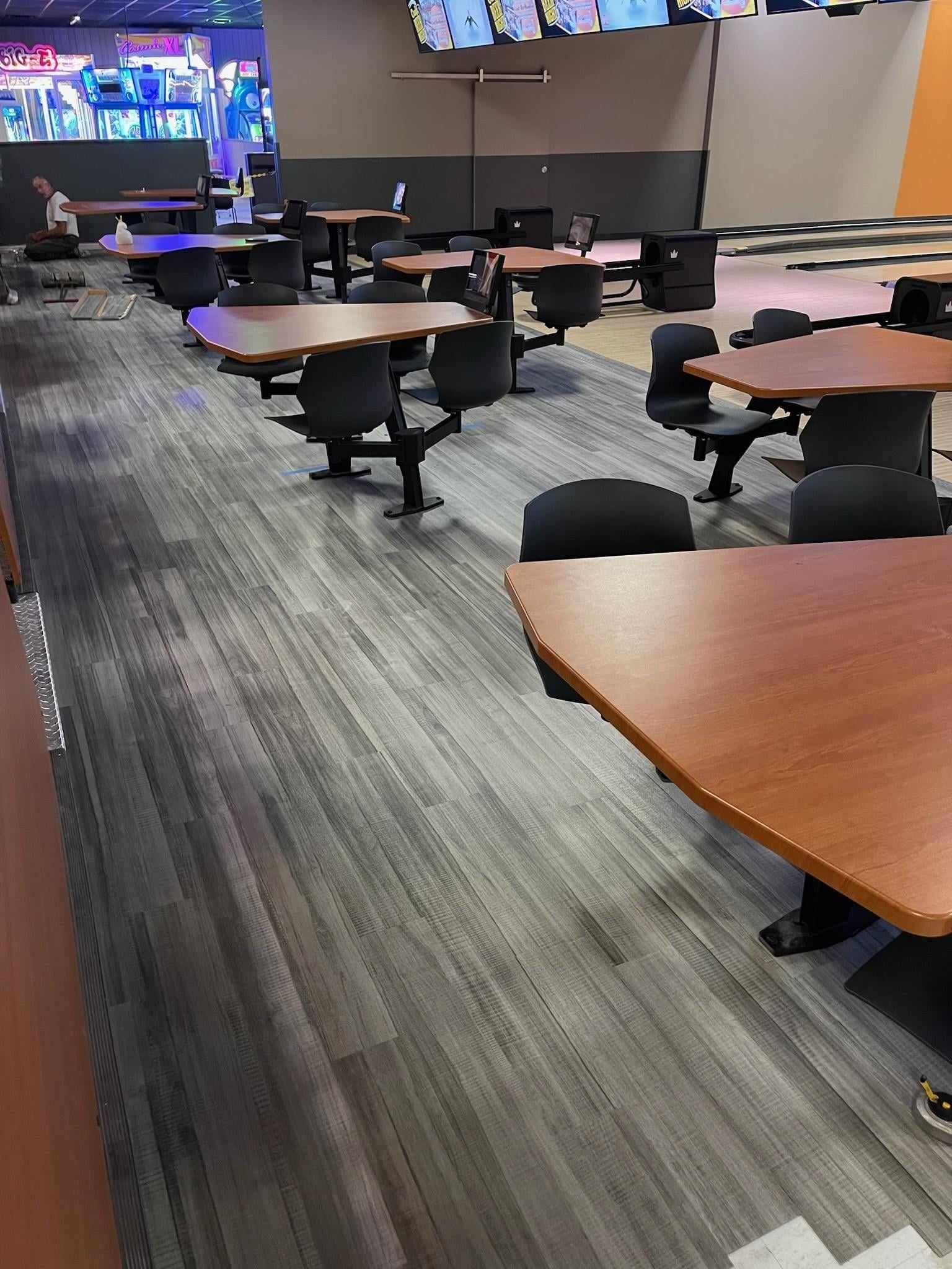 A bowling alley filled with tables and chairs.
