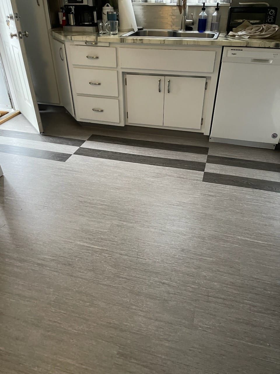 A kitchen with a checkered floor and white cabinets