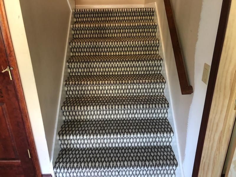 A set of stairs with a patterned carpet on them.