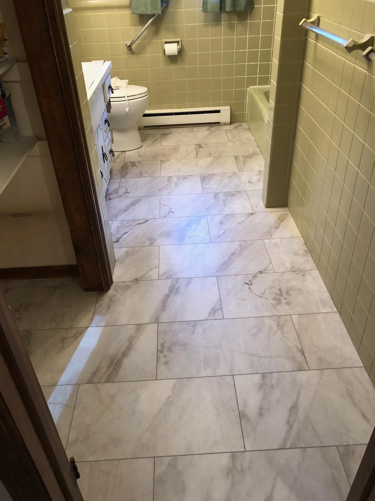 A bathroom with a marble floor and a toilet.
