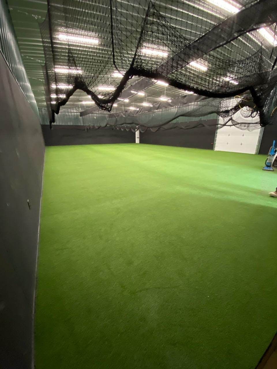 A large indoor soccer field with a net hanging from the ceiling.