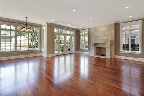 An empty living room with hardwood floors and a fireplace