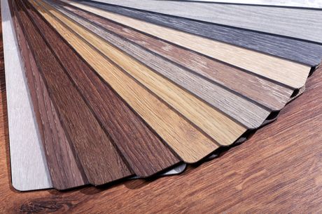 A fan of different types of wood samples on a wooden table.