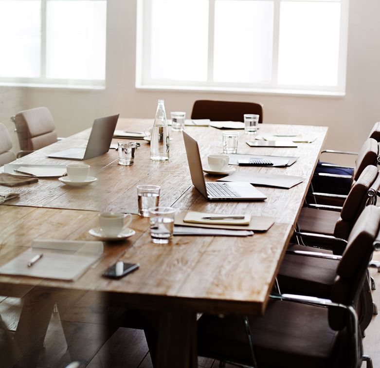 A conference room with a long wooden table and chairs.