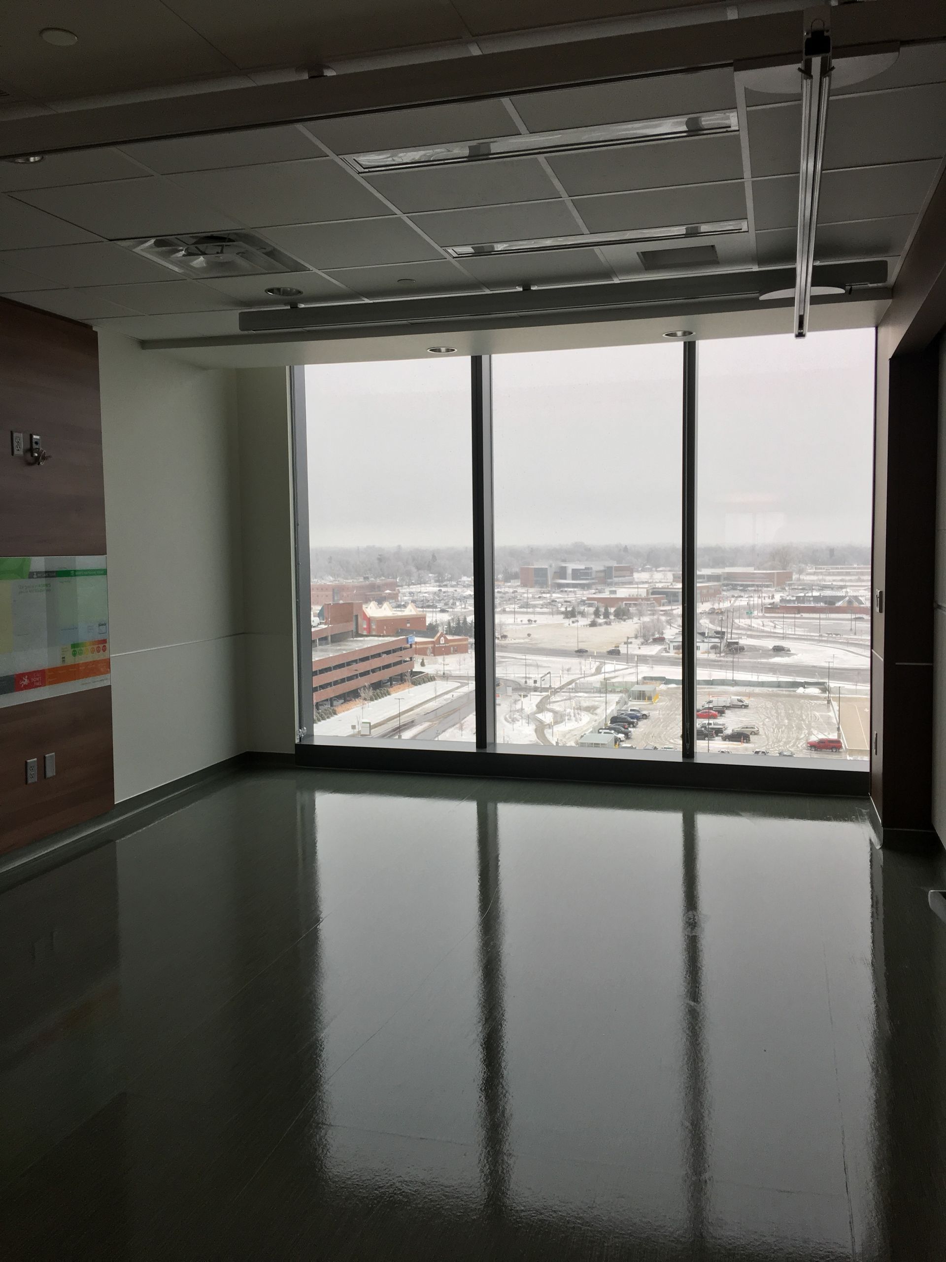 An empty room with a large window and a view of a city