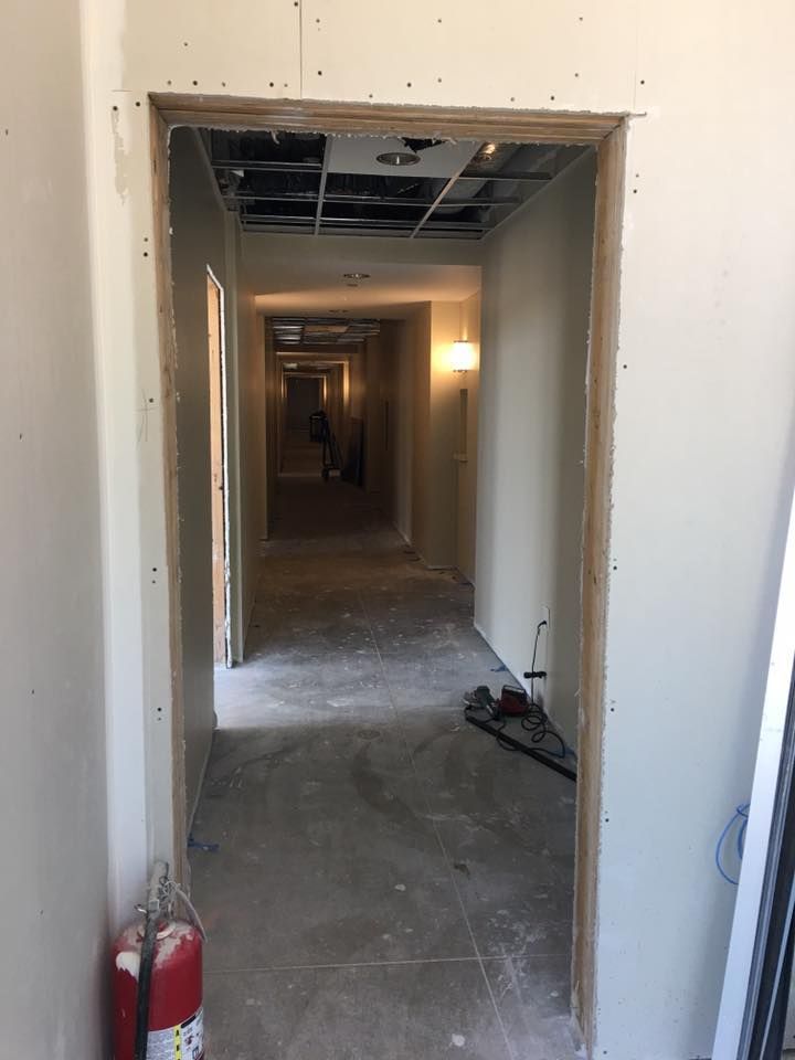 A hallway with a fire extinguisher on the side of it.