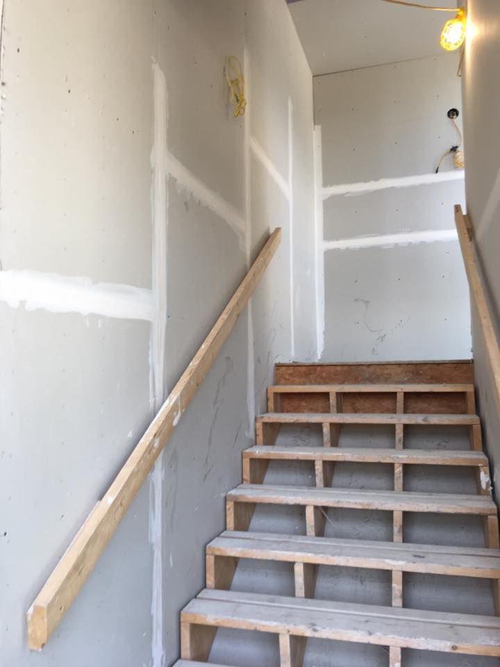 A set of wooden stairs with a wooden railing