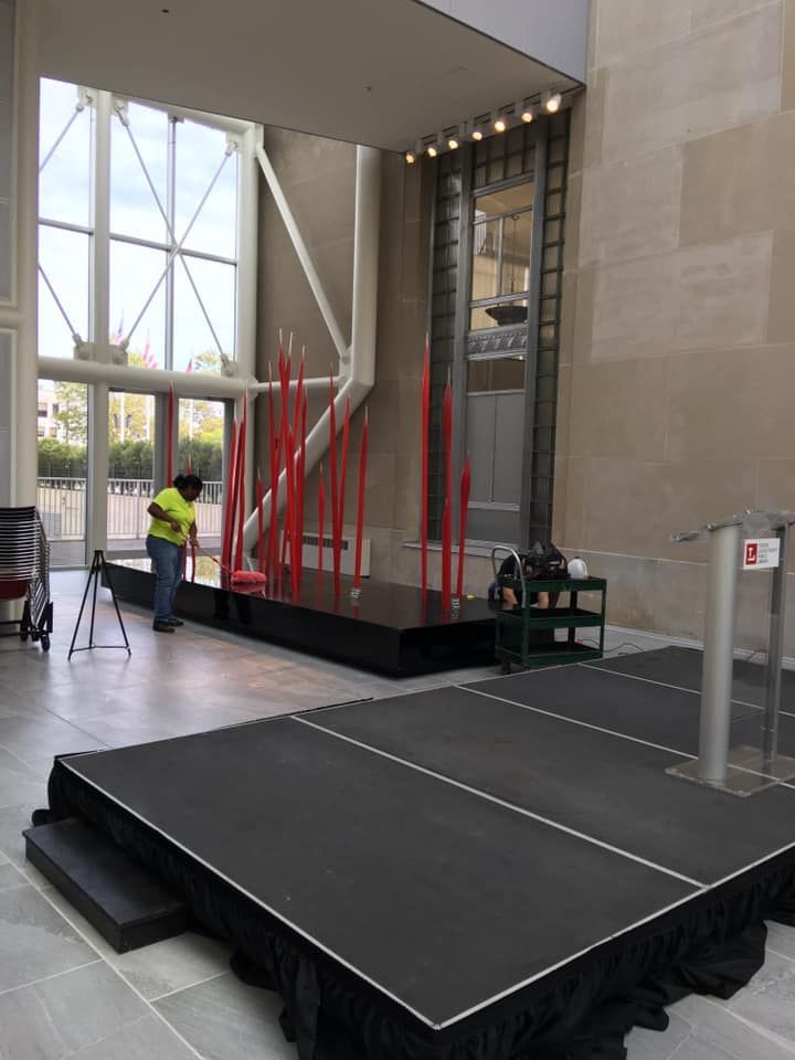 A man is standing on a stage in a large room
