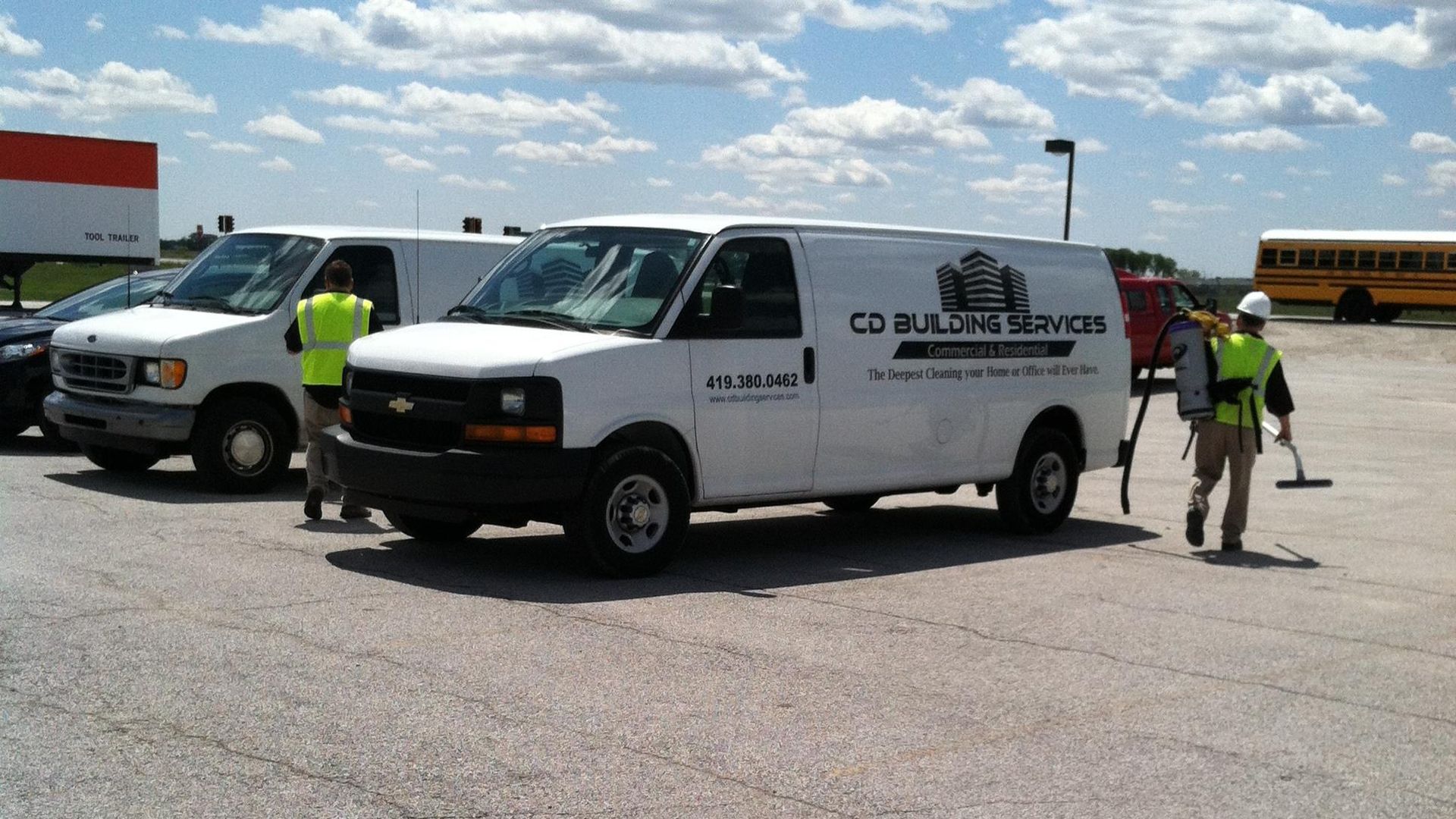 Three cd building services vans are parked in a parking lot