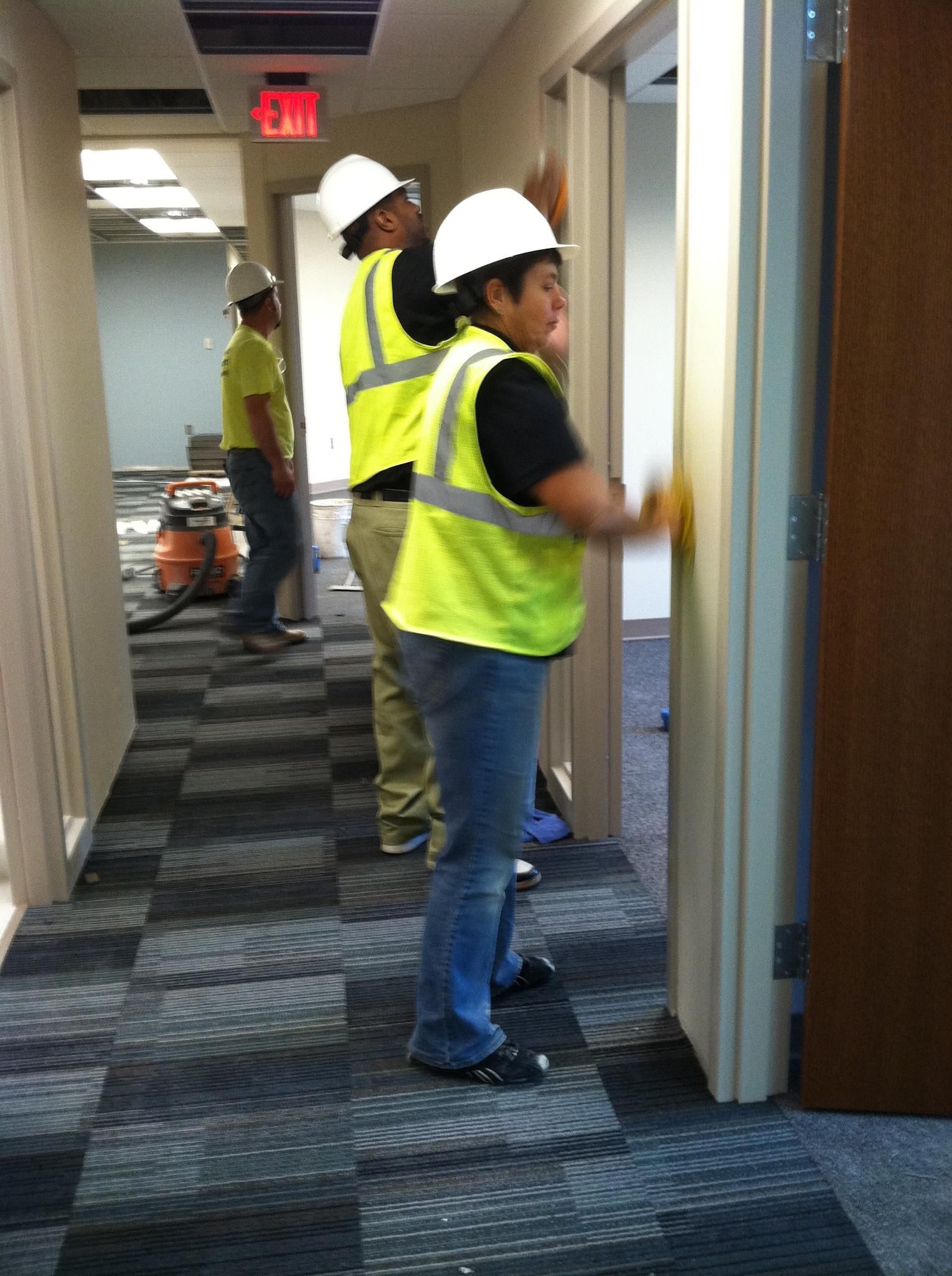 A group of construction workers are working in a hallway