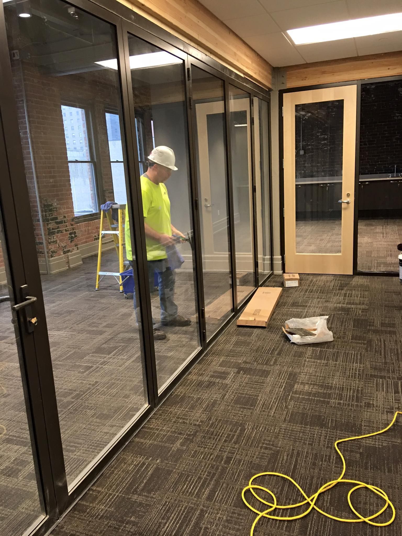 A man is standing in a room with a lot of glass doors.